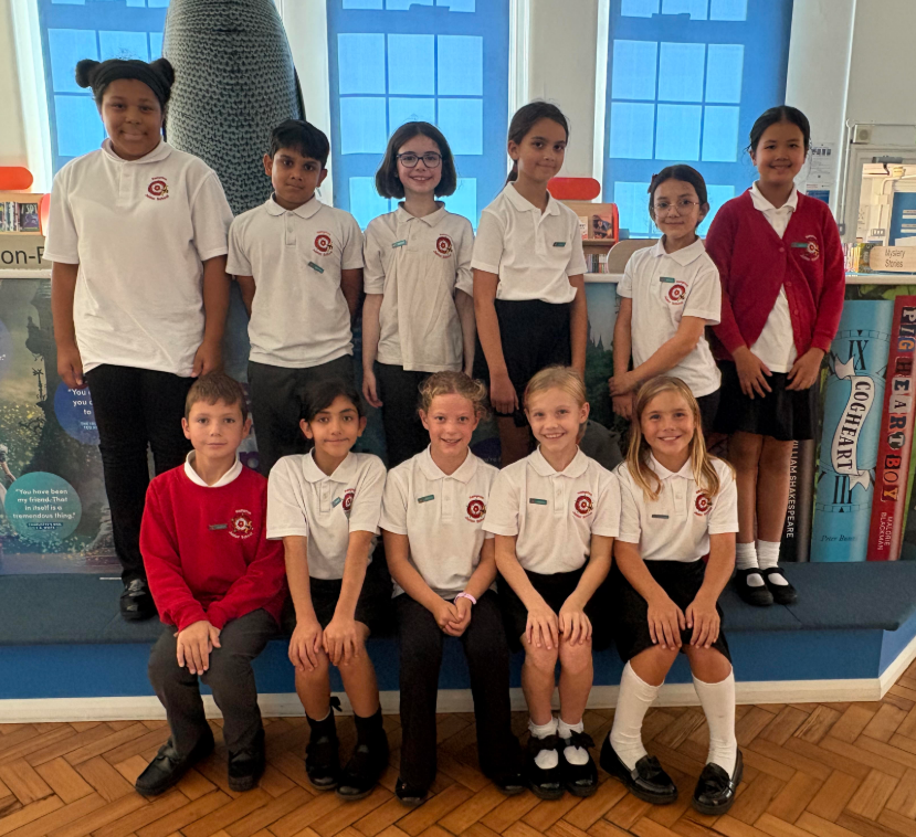 Two girls sitting behind the desk at our weekly Inkpot sale selling stationery to the students 